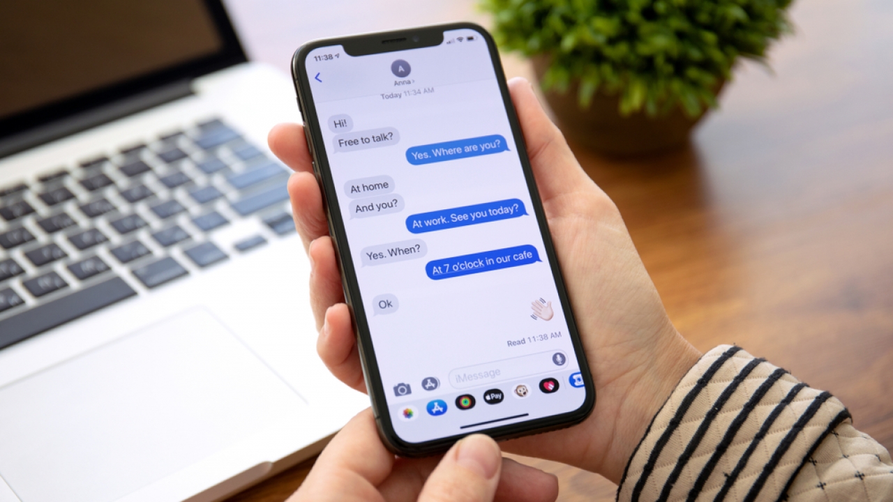 Hand holding phone with text message conversation on screen